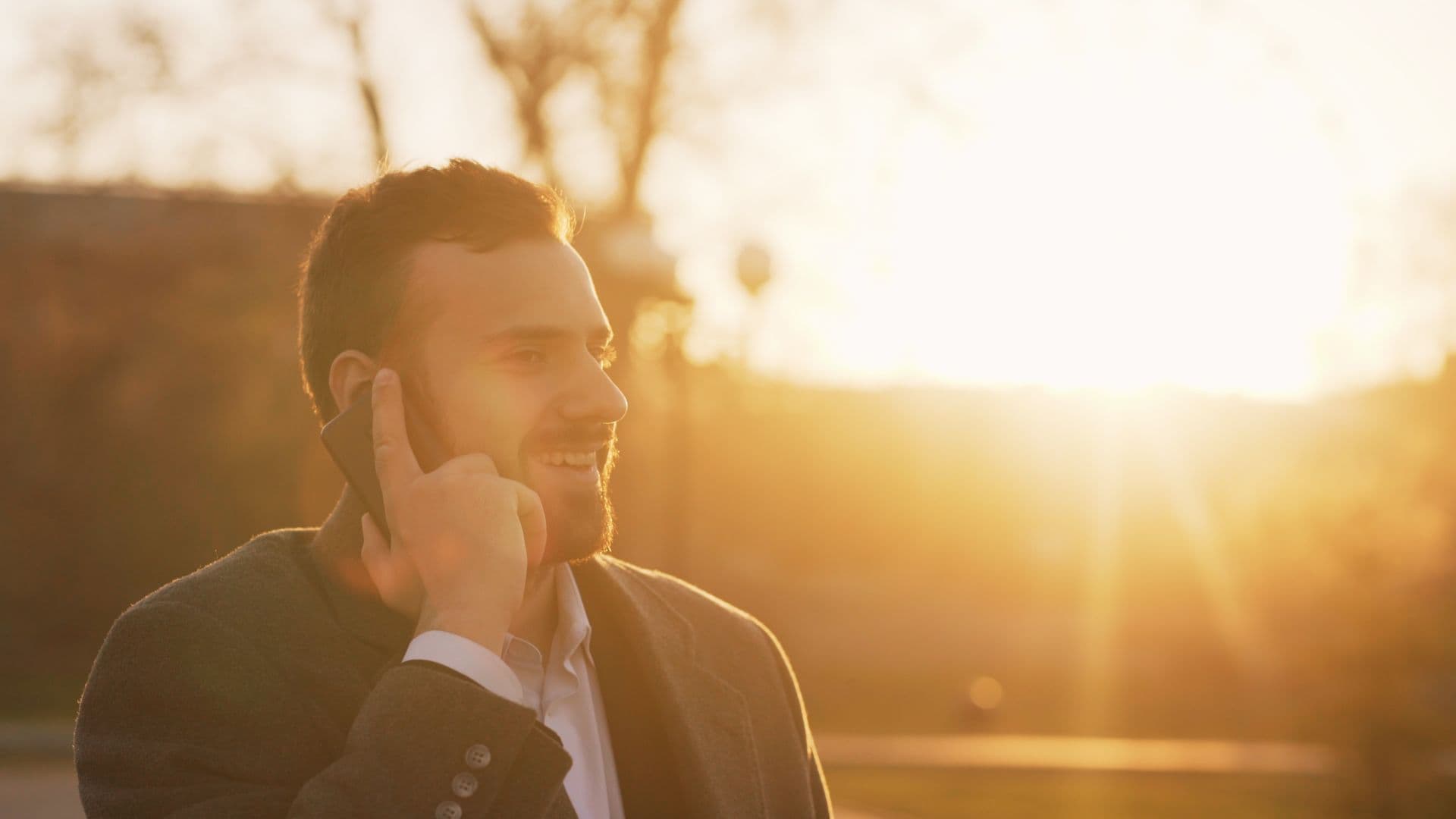 A business owner taking a call outdoors at the end of the working day.